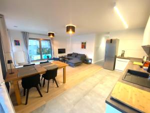 a kitchen and living room with a table and a couch at Brand New Large Family Flat in Center- Parking -N1 in Luxembourg