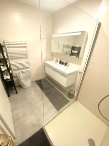 a white bathroom with a sink and a mirror at Brand New Large Family Flat in Center- Parking -N1 in Luxembourg