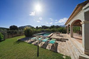 a backyard with a swimming pool and some chairs at Can Jaume in Pollença