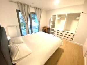 a bedroom with a large white bed and a window at Brand New Large Family Flat in Center- Parking -N1 in Luxembourg