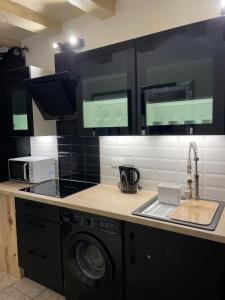 a kitchen with a sink and a washing machine at PopCorn&Netflix in Bourges