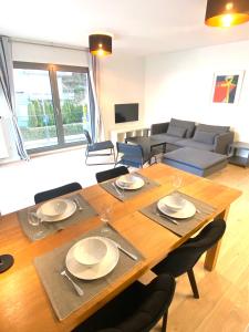 uma sala de estar com uma mesa de madeira e cadeiras em Brand New Large Family Flat in Center- Parking -N1 em Luxemburgo