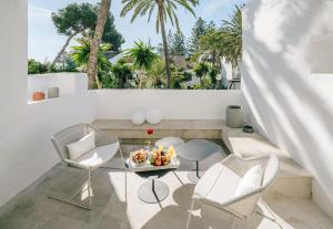 einen Balkon mit einem Tisch, Stühlen und Palmen in der Unterkunft Puente Romano Beach Suites - private apartaments in Marbella