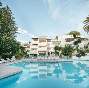 a swimming pool in front of a large building at Puente Romano Beach Suites - private apartaments in Marbella