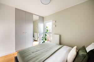 a bedroom with a bed and a large window at Bohema Place - Metro Szwedzka Apartment in Warsaw