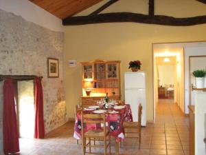 une salle à manger avec une table et un réfrigérateur dans l'établissement Limerac Cottage, à Salles-Lavalette