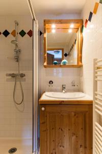 a bathroom with a sink and a shower with a mirror at Lagrange Vacances Le Hameau du Rocher Blanc in Saint-Chaffrey