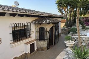 een wit huis met een poort en een palmboom bij Villa Ventura 8 Pers in Pego