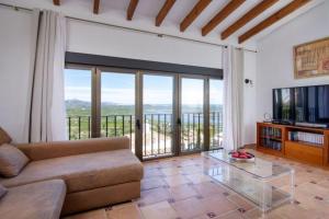 een woonkamer met een bank en een televisie bij Villa Ventura 8 Pers in Pego
