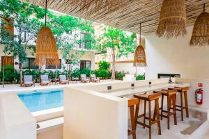 eine Poolbar mit Stühlen, Tischen und einem Pool in der Unterkunft 3 BD between ocean and downtown with amenities - Aldea Zama in Tulum
