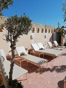 - une rangée de tables et de chaises blanches sur la terrasse dans l'établissement DAR MAR'OUKA , Maison d'hôtes, à Marrakech