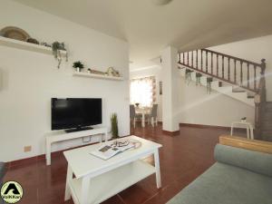 salon z telewizorem i stołem w obiekcie VolKKanrentals SunBeam House w mieście Famara