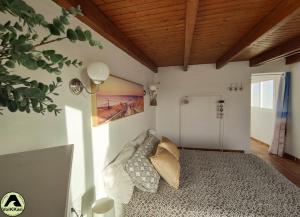 sypialnia z łóżkiem i poduszkami w obiekcie VolKKanrentals SunBeam House w mieście Famara
