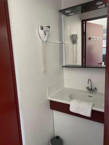 a bathroom with a sink and a phone on the wall at Fasthotel Mont de Marsan in Mont-de-Marsan