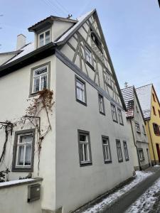 a white building with windows on a snowy street at Ferienwohnungen auf der Stadtmauer 