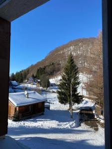 a view from a window of a house in the snow at Appartement Col de Latrape in Aulus-les-Bains