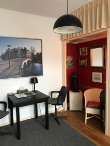 Habitación con escritorio, sillas y una pintura en la pared. en Six en Ámsterdam