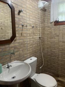 a bathroom with a toilet and a sink at Cantinho do Sussego 2 in Campos do Jordão