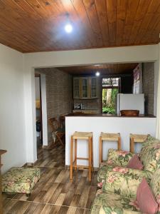 a living room with two couches and a kitchen at Cantinho do Sussego 2 in Campos do Jordão