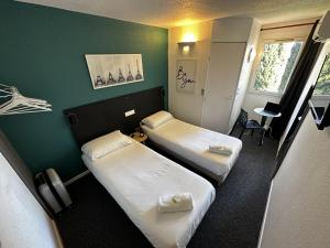 מיטה או מיטות בחדר ב-L'Escale d'Alès HOTEL
