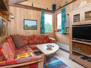 a living room with a couch and a table and a tv at Holiday home Hovborg IX in Hovborg