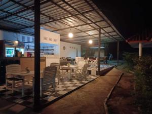 a patio with tables and chairs on a checkered floor at PaiFamilyRESORT in Pai