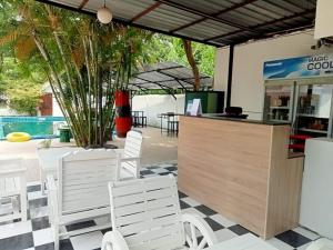 a restaurant with white chairs and a counter at PaiFamilyRESORT in Pai