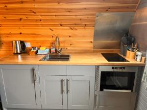 a kitchen with a sink and a microwave at Sea Breeze Pod in Fort William