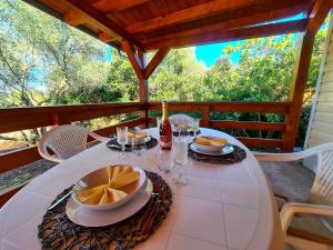 a white table with plates of food on a porch at Gabi Mobile home in Banj