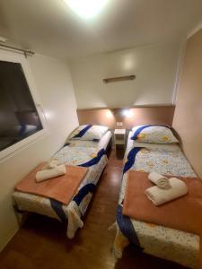 Banj的住宿－Gabi Mobile home，小房间设有两张床和窗户