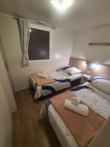 two beds in a small room with a window at Gabi Mobile home in Banj