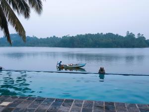 a man in a boat in a body of water at MyHoliday Home @ Bandaragama in Bandaragama