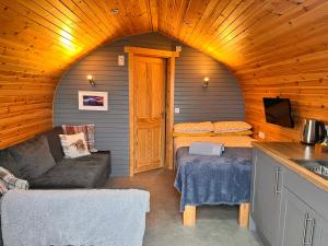 Habitación pequeña con sofá y cocina en una cabaña en Sea Breeze Pod, en Fort William