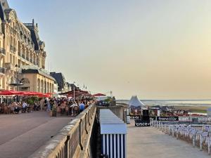 a group of people sitting on a bridge near the beach at Studio chic, hyper centre, 4 minutes de la plage in Cabourg