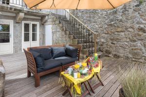 een patio met een bank, een tafel en een parasol bij GuestReady - La Maison Aires Gouveia 3 in Porto