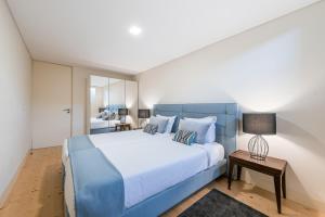 een slaapkamer met een groot blauw bed met een blauw hoofdeinde bij GuestReady - La Maison Aires Gouveia 3 in Porto