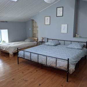 - 2 lits dans une chambre dotée de parquet dans l'établissement Bienvenue au Barail, maison en pleine nature, à Sérigné