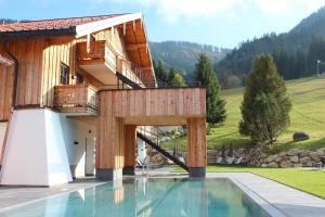 una casa con piscina al lado de un edificio en Unternberg Hof Ruhpolding en Ruhpolding