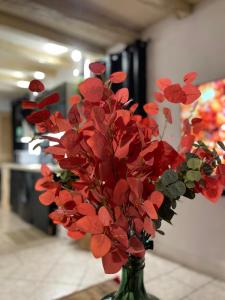 a green vase filled with red flowers on a table at PopCorn&Netflix in Bourges