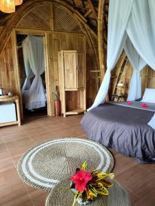 a bedroom with a bed and a table with a flower on the floor at Great Mountain Views Villa Resort in Sidemen