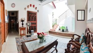 a living room with a table with flowers on it at The Cabin Purwokinanti Hotel in Yogyakarta