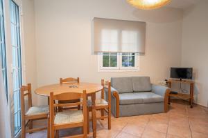 a living room with a table and a chair and a couch at Captain's Villas in Katelios