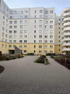 un gran edificio de apartamentos con un aparcamiento enfrente en Klimatyzacja - przy centrum Onkologii klinice Novum dla pary bądź 4 osób, en Varsovia