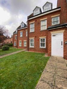 a large brick building with a white garage at Luxury Town centre apartment walking distance to RSC theatre in Stratford-upon-Avon