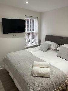 a bedroom with two beds and a flat screen tv at Luxury Town centre apartment walking distance to RSC theatre in Stratford-upon-Avon