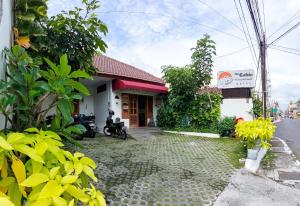 een huis aan de kant van de weg met motorfietsen geparkeerd bij The Cabin Purwokinanti Hotel in Yogyakarta