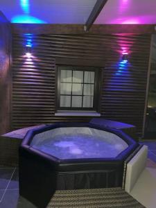a room with a hot tub with purple lights at Gîte Au Crépuscule du Belvédère in Dompierre-Becquincourt