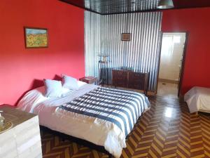 um quarto com paredes vermelhas e uma cama num quarto em La Antonieta Estancia de Mar em Dos Pozos