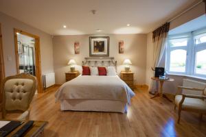 a bedroom with a bed and two tables and a chair at The Tides Ballybunion in Ballybunion