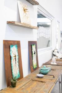 Little Square Arona في أرونا: طاولة خشبية مع قطعتين من الفن على الحائط